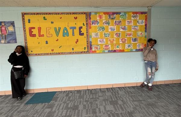 students standing in front of billboard